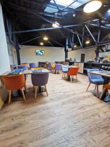a dining room with tables and chairs and a kitchen at Aux Ateliers in Miserey-Salines +30 photos