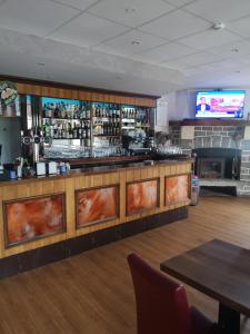 un bar dans un restaurant avec une télévision derrière dans l'établissement L'auberge des quatre routes, à Albussac