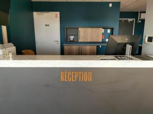 an office with a reception desk with a reception counter at Aux Ateliers in Miserey-Salines