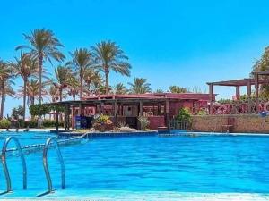 a large swimming pool in a resort with palm trees at palmera el sokhna in Suez
