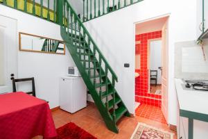 a bathroom with a green staircase and a red tile floor at Casa Doina in Baile Felix