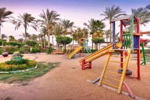 een speeltuin met een glijbaan in een park met palmbomen bij palmera el sokhna in Suez