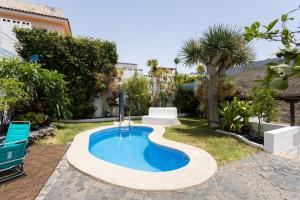 una pequeña piscina en un patio con 2 sillas azules en Home2Book Stunning Villa near Las Teresitas&Anaga, en Santa Cruz de Tenerife