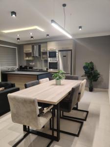 cocina y comedor con mesa de madera y sillas en Qawra Apartment, en St Paul's Bay