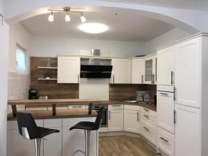 a kitchen with white cabinets and a table and chairs at Mozart Apartments in Vienna