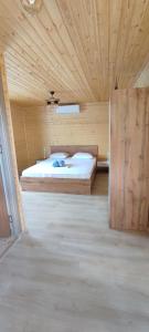 sypialnia z łóżkiem w drewnianym pokoju w obiekcie Căsuța din livadă w mieście 2 Mai