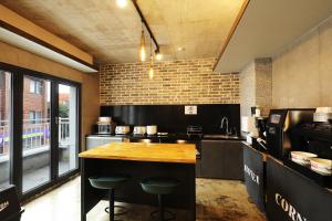 a large kitchen with a counter and stools in it at Cornerstone Hotel in Seogwipo