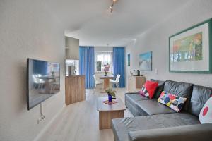 un soggiorno con un divano e un tavolo di Residenz Ostseestrand Appartement 4 a Scharbeutz