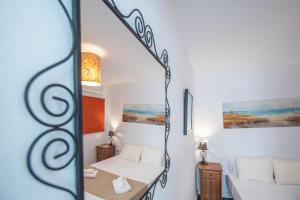 Habitación pequeña con cama y espejo. en Apartamento Posadilla Cadiz, en Cádiz
