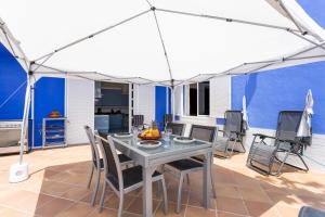 un patio con una mesa con sillas y una sombrilla en Home2Book Stunning Villa near Las Teresitas&Anaga, en San Andrés
