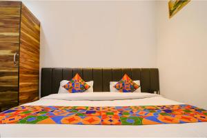 een slaapkamer met een bed met een kleurrijk dekbed bij FabHotel JP Residency in Amritsar