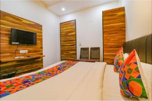 een slaapkamer met een bed en een flatscreen-tv bij FabHotel JP Residency in Amritsar