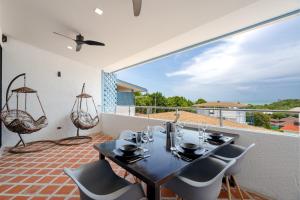 ein Esszimmer mit einem Tisch und Stühlen auf dem Balkon in der Unterkunft Villa Lila in Ko Lanta