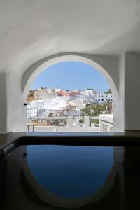 a room with a window with a view of a city at Acave Santorini Suites in Vóthon