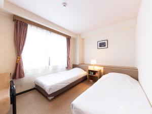 Postel nebo postele na pokoji v ubytování Tabist Business Hotel R Side Kanazawa