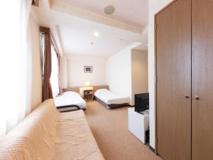 Postel nebo postele na pokoji v ubytování Tabist Business Hotel R Side Kanazawa