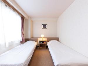 Postel nebo postele na pokoji v ubytování Tabist Business Hotel R Side Kanazawa