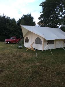 uma grande tenda num campo com um camião vermelho em Amelia Vera em Lincolnshire