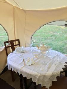 einen Tisch in einem Zelt mit einem weißen Tischtuch in der Unterkunft Amelia Vera in Lincolnshire