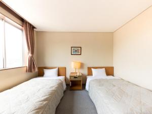 Postel nebo postele na pokoji v ubytování Tabist Kanko Business Hotel Matsuyama Hida Takayama + 28 fotografií