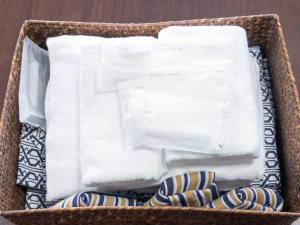 a basket filled with towels and striped socks at Tabist Miyoshi Ryokan Odawara Manazuru in Odawara