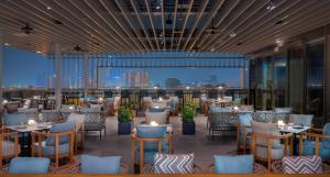 a restaurant with tables and chairs and a view of the city at Hyatt Regency Phnom Penh in Phnom Penh