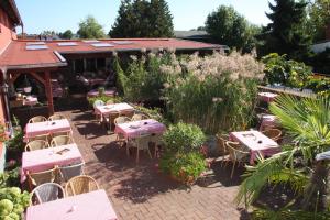 a restaurant with tables and chairs in a garden at Hotel Da Gianni GmbH in Oranienburg