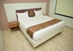 Un pat sau paturi într-o cameră la Hotel Crown Royal