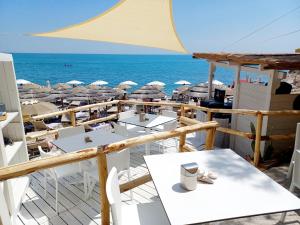 a view of the beach with tables and umbrellas at AH Premium Baia dei Faraglioni in Mattinata