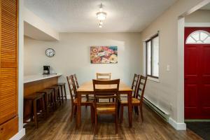 comedor con mesa y sillas y puerta roja en Whistler Village - Redwood 10 condo, en Steamboat Springs