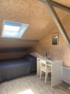 1 dormitorio con cama, escritorio y ventana en Domaine de La Méniguère, en Saint-Gein