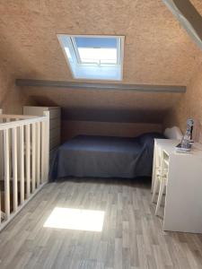 a attic bedroom with a bed and a skylight at Domaine de La Méniguère in Saint-Gein