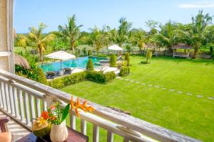 a balcony view of a yard with a swimming pool at Canggu Wooden Green Paradise in Canggu
