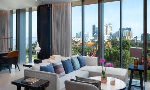 a living room with a white couch and a large window at Hyatt Regency Phnom Penh in Phnom Penh
