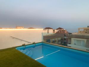 Apartamento NEPTUNO con piscina a 50 mt de la playa في مورش: مسبح على سطح مبنى