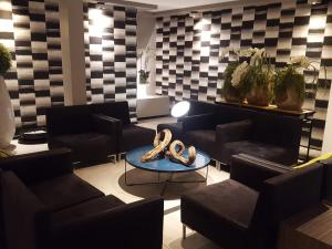 einen Salon mit Stühlen und einem Tisch mit Schuhen darauf in der Unterkunft Hotel Floris Arlequin Grand-Place in Brüssel