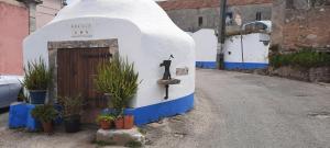 a small house with a pizza oven on the side of a road at Casa Mateus - Colares, Parque Natural Sintra Cascais in Sintra