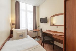 a hotel room with a bed and a desk at Hotel Hamburg Stadtzentrum in Hamburg