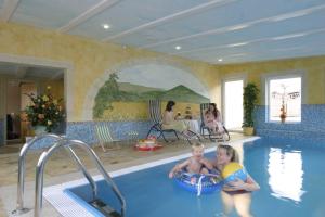 a couple of people in a swimming pool at Landhotel Heidekrug in Dohma