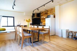 a kitchen and dining room with a wooden table and chairs at Shirakabanoyado - Minato in Osaka