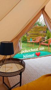 a table and a chair in a tent at Dream Glamping-Wakacyjna Wioska-Namioty z ogrzewaniem in Bałtów