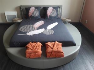 Una cama con dos pares de zapatos y toallas. en L'alchimie33, en Caudrot