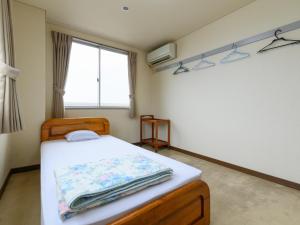 una camera da letto con un letto e una finestra di Tabist Business Hotel Kaigansou Gamagori a Gamagōri