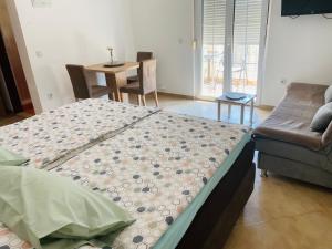 um quarto com uma cama, um sofá e uma mesa em Apartmani Slavko em Fažana