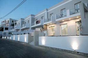 a row of white apartments with balconies at night at Hyperion Hotel in Myrties