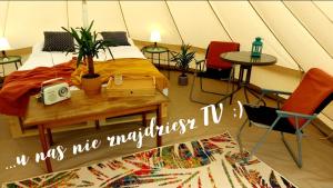 a room with a bed and a table and chairs at Dream Glamping-Wakacyjna Wioska-Namioty z ogrzewaniem in Bałtów