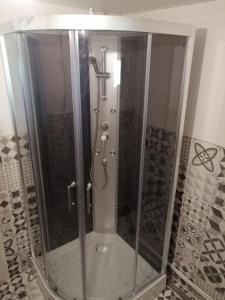 a shower with a glass door in a bathroom at Petite maison dans les bois 