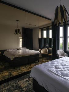 a bedroom with a bed and a living room at Bed & Breakfast Maison Noire Westende-bad incl parking & ontbijt in Middelkerke