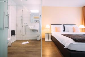 ein Schlafzimmer mit einer Dusche und einem Bett sowie ein Badezimmer in der Unterkunft Schützen Steffisburg in Thun