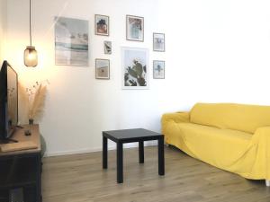 a living room with a yellow couch and a table at Naked House Sardinia in Bari Sardo